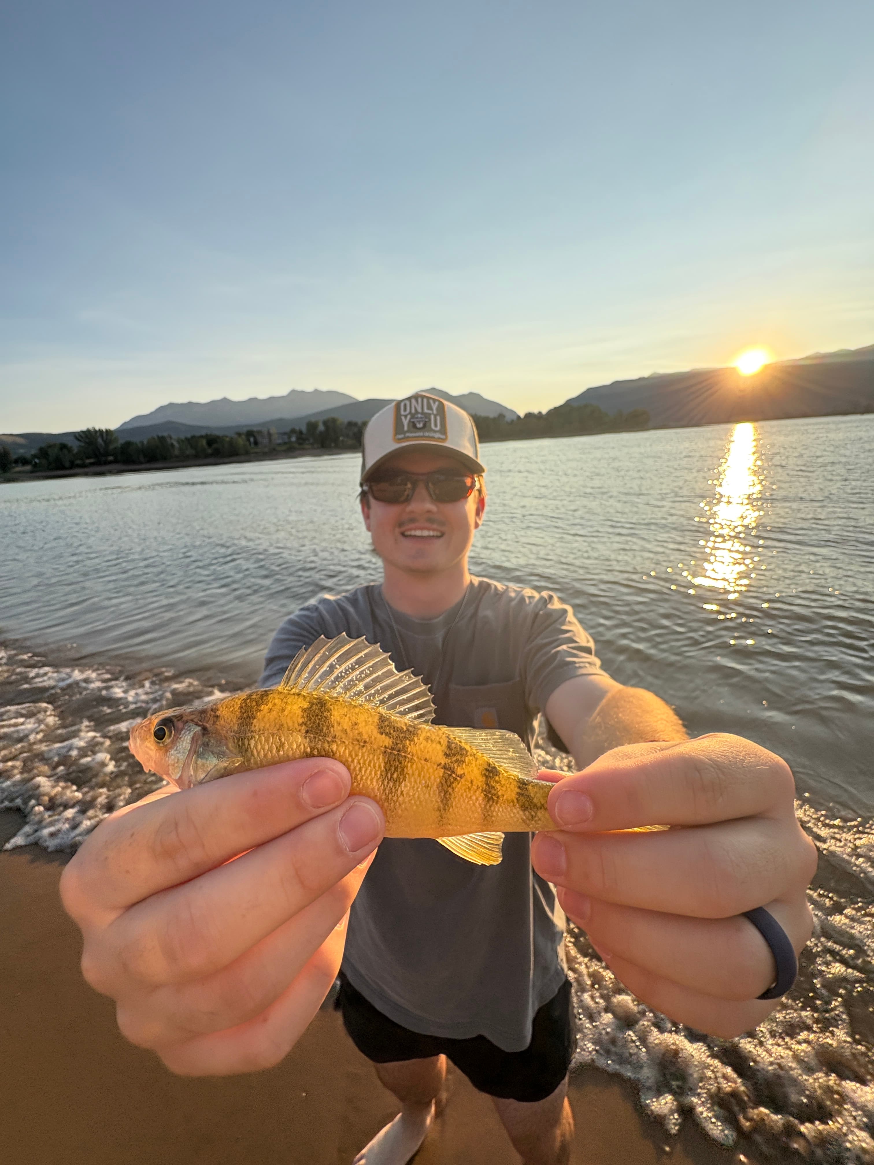 Holding a fish at sunset