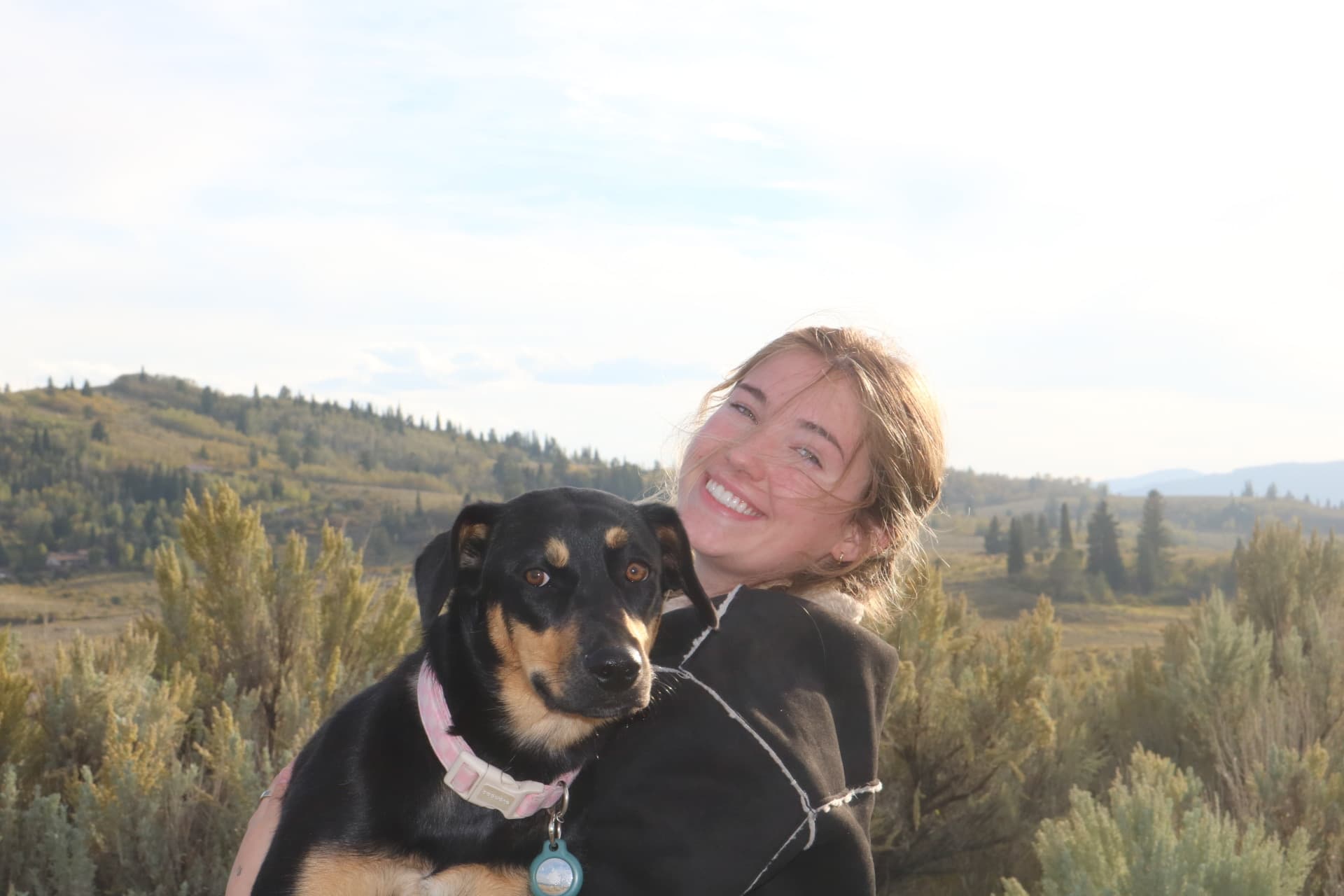 Wife laughing with the dog tucked against her shoulder